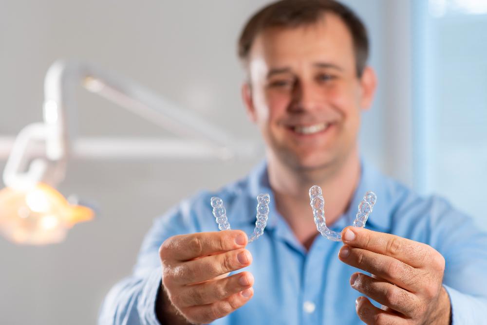 man holding invisalign clear aligners | invisalign goffstown nh