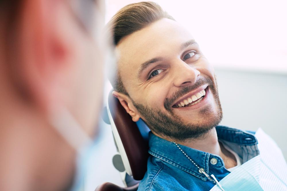 man sitting in dental exam chair | dentist manchester nh