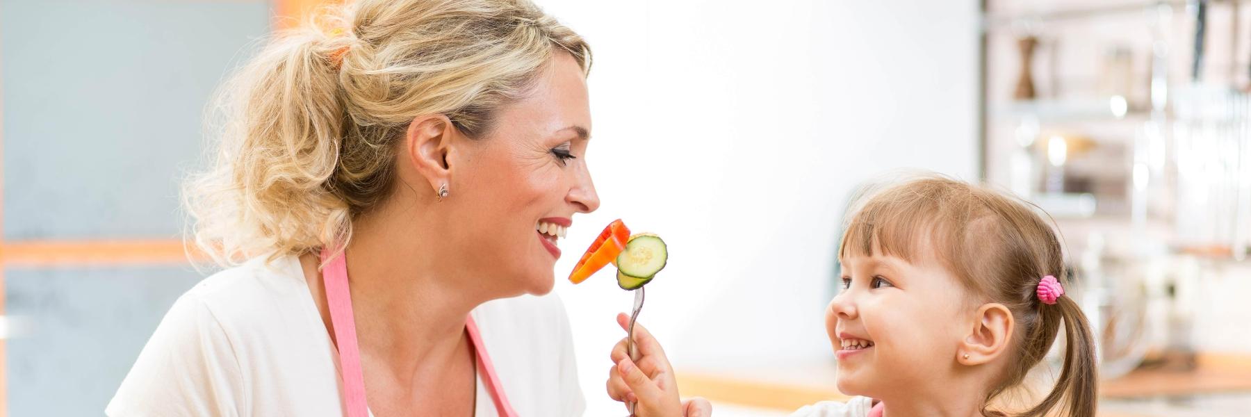small child feeding woman vegetables l goffstown dentist