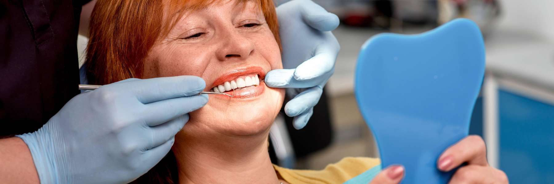 woman smiling with mirror | goffstown dentist